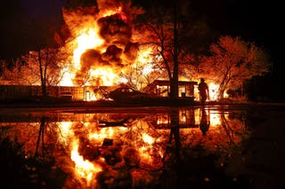 A firefighter works at the site of a recyclable materials warehouse hit by a Russian missile strike, in Kyiv on 16 April